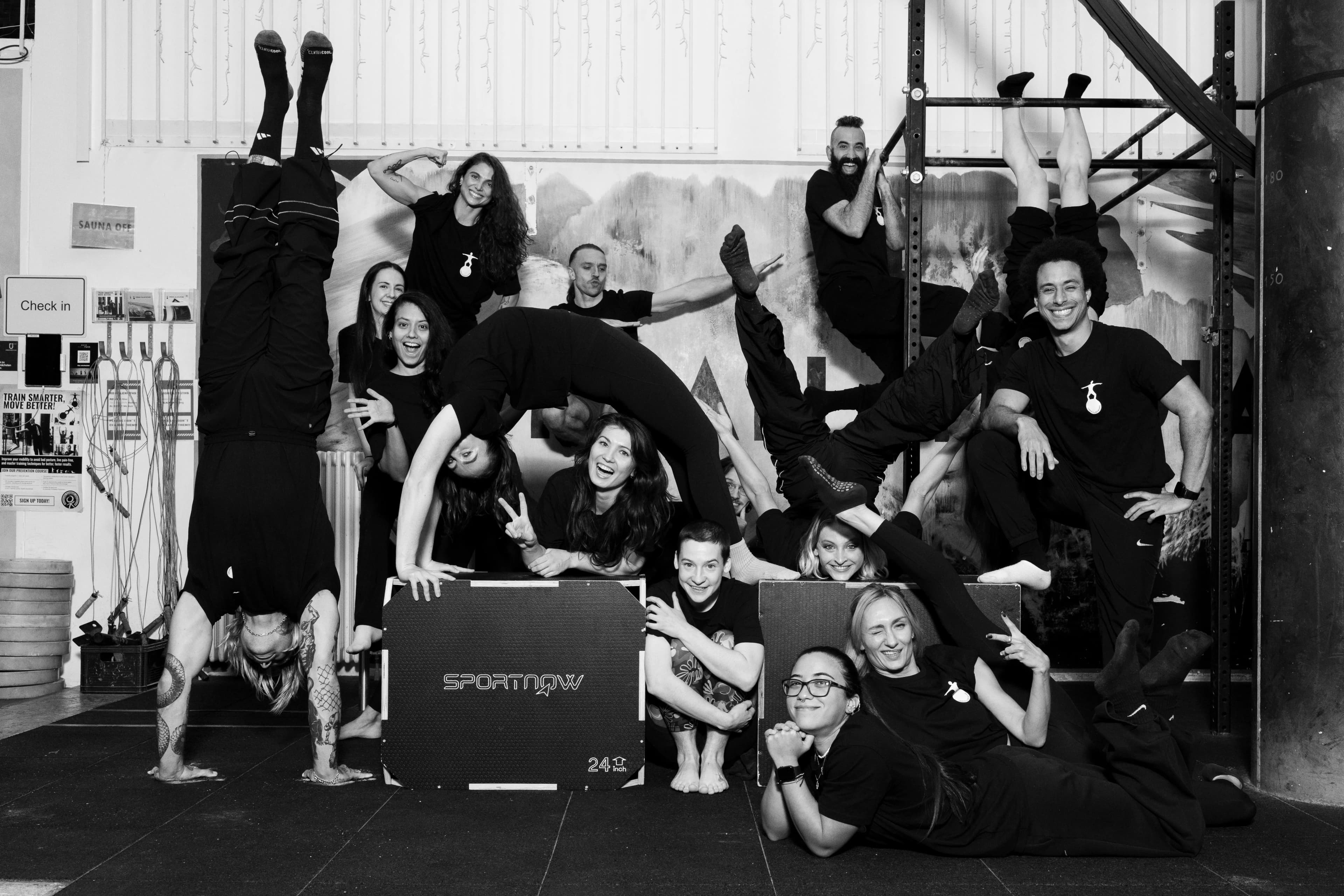 Schwarzweiß: das Urban-Gladiators-Team im Studio — Handstand, Brücke, Kicks vor den Plyo-Boxen